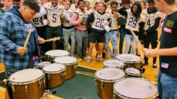 Football Team Hypes Marching Band during Pep Rally